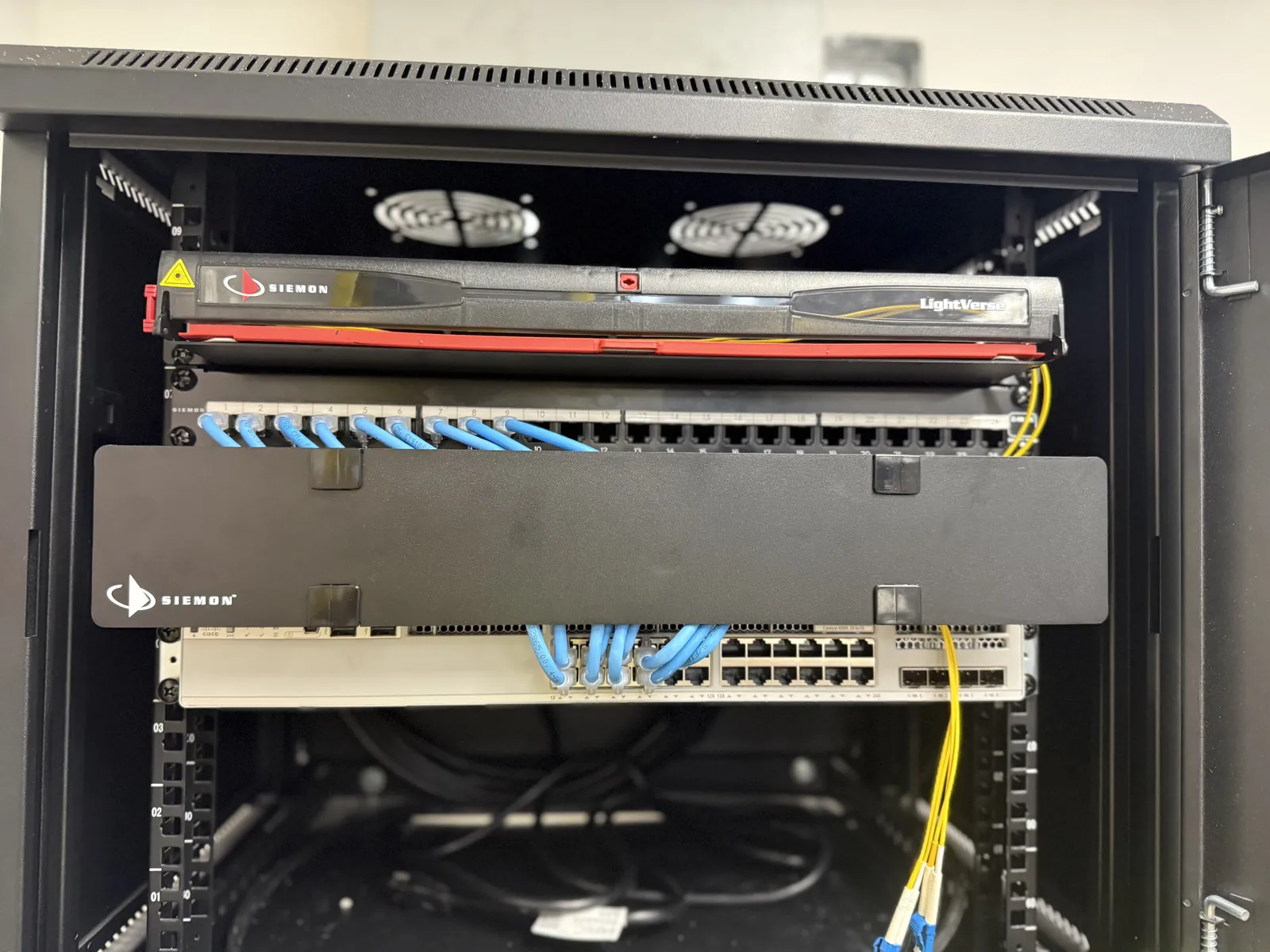 Rack con panel de fibra óptica Siemon LightVerse, patch panel y switch Cisco, con cableado ordenado