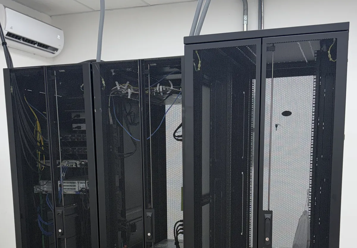 Racks del data center con puertas perforadas y cableado de fibra y cobre